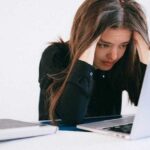 Frustrated and overworked woman on Laptop