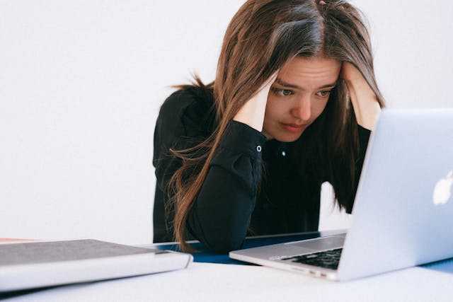 Frustrated and overworked woman on Laptop